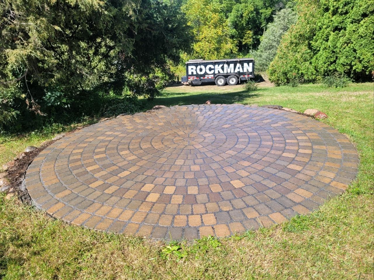 Circular paver patio in a landscaped yard